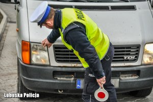 policjant sprawdza działanie świateł pojazdu