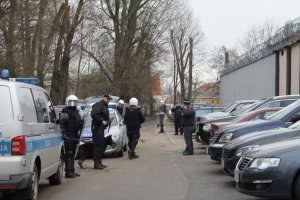 Policjanci przygotowujący się do wejścia do budynku aresztu