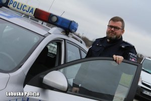 policjant stojący przy radiowozie