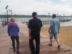 policjant i pracownicy ośrodka na pomoście