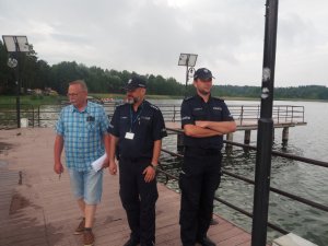 policjanci i pracownik ośrodka stoją na pomoście