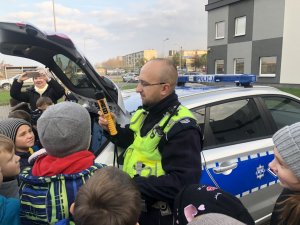 policjant pokazuje urządzenie do badania trzeźwości