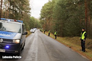 radiowóz i policjanci przy drodze