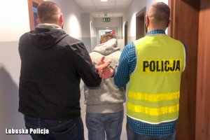 Policjanci prowadzą zatrzymanego