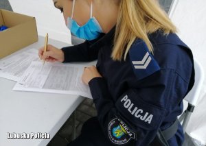 policjanta w trakcie wypisywania dokumentów do pobrania krwi