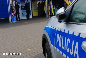 radiowóz policyjny. W tle stoisko informacyjne Komendy Powiatowej Policji w Międzyrzeczu