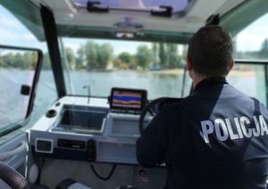 policjant w łodzi dbający o bezpieczeństwo plażowiczów