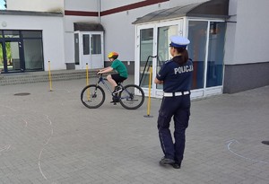 policjantka egzaminuje młodego rowerzystę w trakcie egzaminu na kartę rowerową
