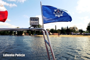 flaga policji wodne w tle jezioro oraz plaża