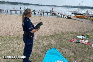 policjantka na tle plaży w trakcie kontroli obozów