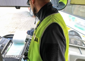 policjant w trakcie kontroli dokumentów kierowcy autokaru