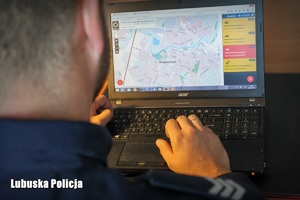 policjant sprawdzający krajową mapę zagrożeń na komputerze