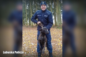 policjant trzymający na smyczy psa służbowego