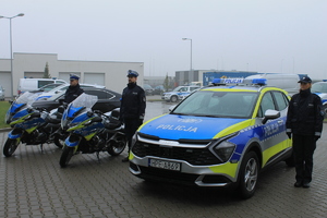 policjanci w trakcie uroczystości przekazania i poświęcenia radiowozu. Funkcjonariusze stojący przy pojazdach służbowych