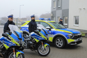 policjanci w trakcie uroczystości przekazania i poświęcenia radiowozu . funkcjonariusze stojący przy pojazdach służbowych