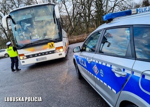 policjanci w trakcie kontroli autobusu. Na zdjęciu widać radiowóz policyjny w tle kontrolowany przez funkcjonariuszy autobus