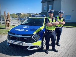 policjanci na tle radiowozu