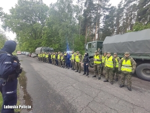 mundurowi ustawieni w jednej linii przy pojazdach wojskowych