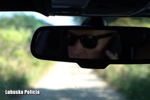 zdjęcia z wnętrza samochodu, zbliżenie na lusterko wsteczne i mężczyznę rozmawiającego przez telefon