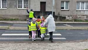 policjant edukuje dzieci bezpiecznego przejścia dla pieszych