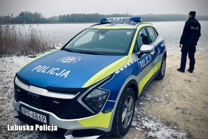 radiowóz i stojący policja na tle zamarzniętego jeziora