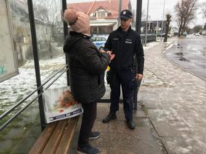 policjant wręcza odblaski seniorce