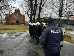 policjant i uczniowie w trakcie treningu w pododdziałach zwartych