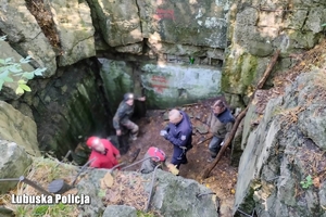 wejście do podziemnych bunkrów. Na zdjęciu ratownicy i policjant