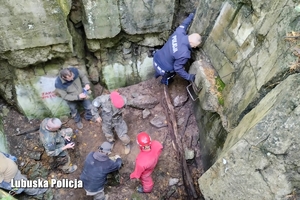 wejście do podziemnych bunkrów. Na zdjęciu ratownicy i policjant