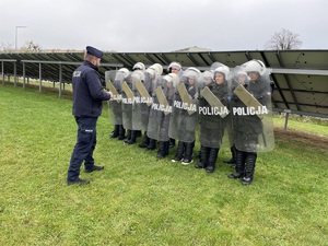 policjant w trakcie szkolenie uczniów pracy w pododdziałach zwartych