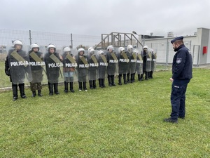 policjant w trakcie szkolenie uczniów pracy w pododdziałach zwartych