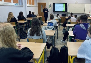 policjanta prowadzi zajęcia dla młodzieży w klasie