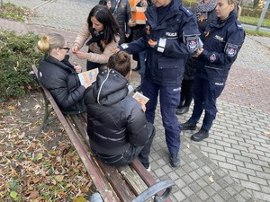 policjanci i pracownicy Ośrodka Pomocy Społecznej rozdają pomarańczowe wstążki