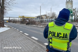 policjant w trakcie dokonywania pomiaru prędkości na drodze