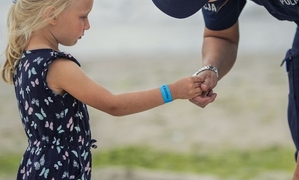 na zdjęciu widzimy dziewczynkę, która podaje dłoń dla policjanta