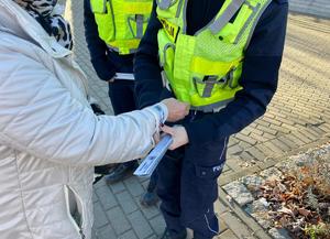 na zdjęciu policjantki i piesza, której wręczają odblask